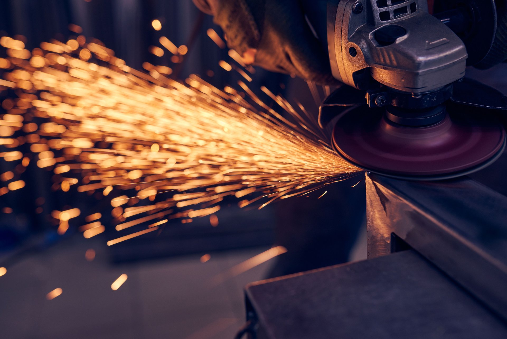 worker-cutting-metal-with-grinder-sparks-while-gr-2023-11-27-05-29-35-utc